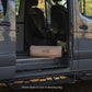 van interior with a LUNO air mattress in the storage bag on the floor, surrounded by trees outside.