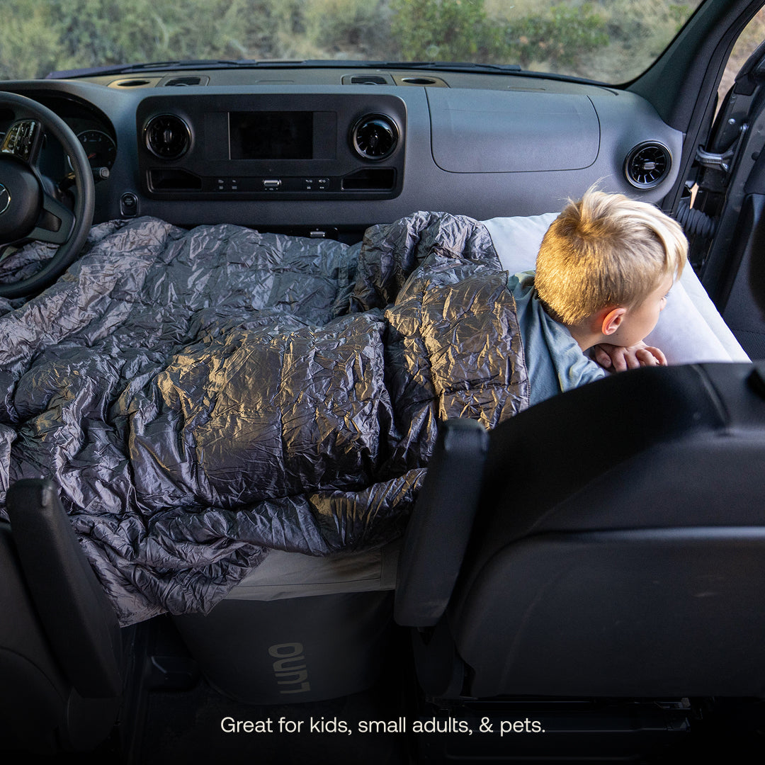 Child lying on a luno air mattress in a van with text 'Great for kids, small adults, & pets.'