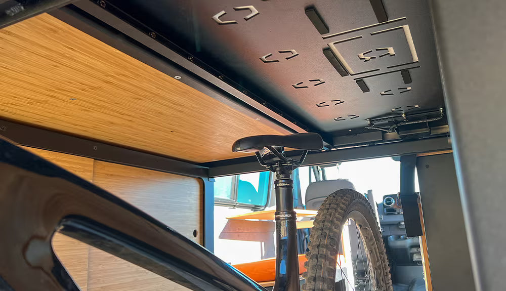 Sandy Interior Nomad Bed with bike underneath 